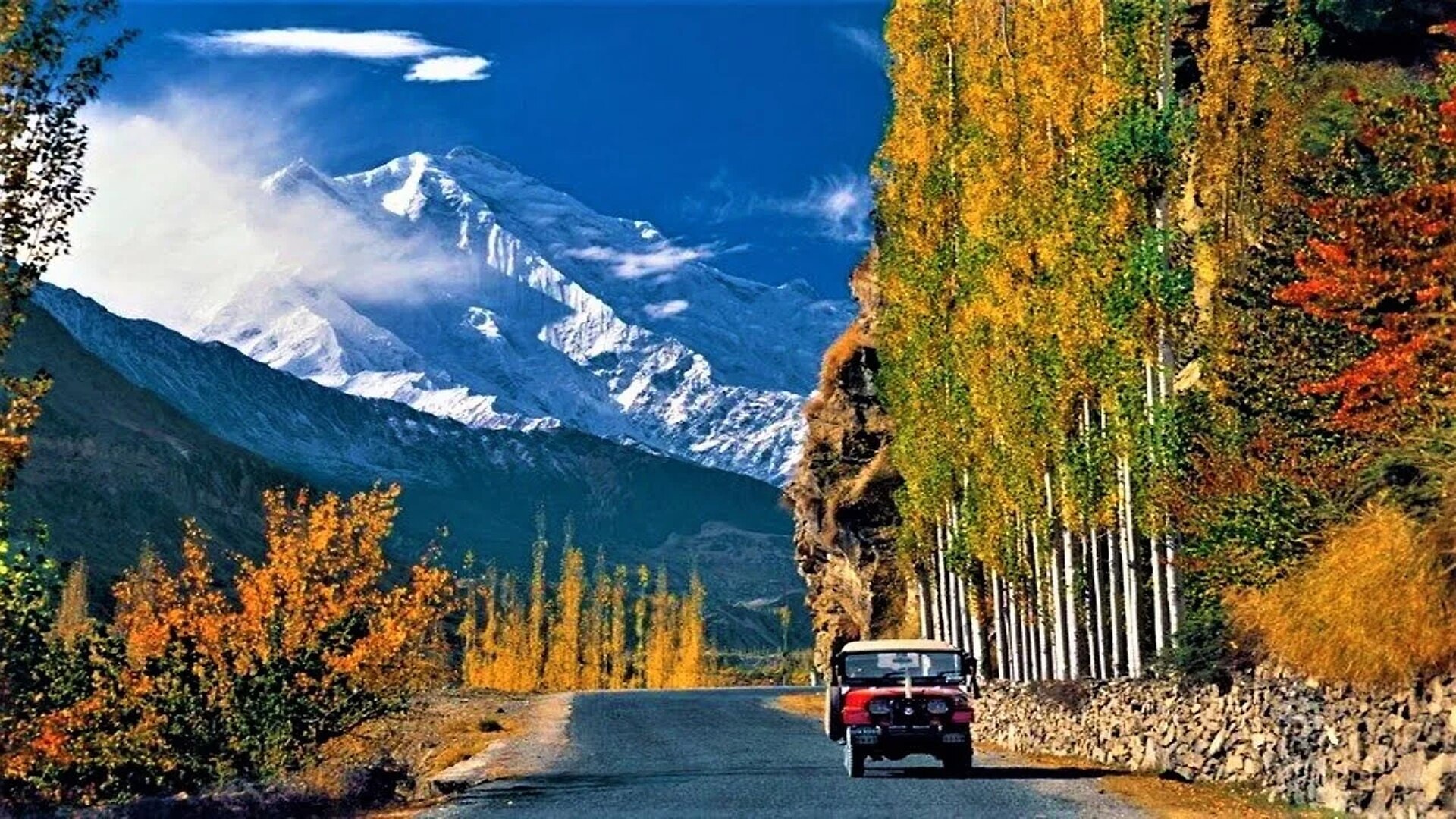 The Karakoram Highway running past golden poplars below Rakaposhi in Hunza Valley